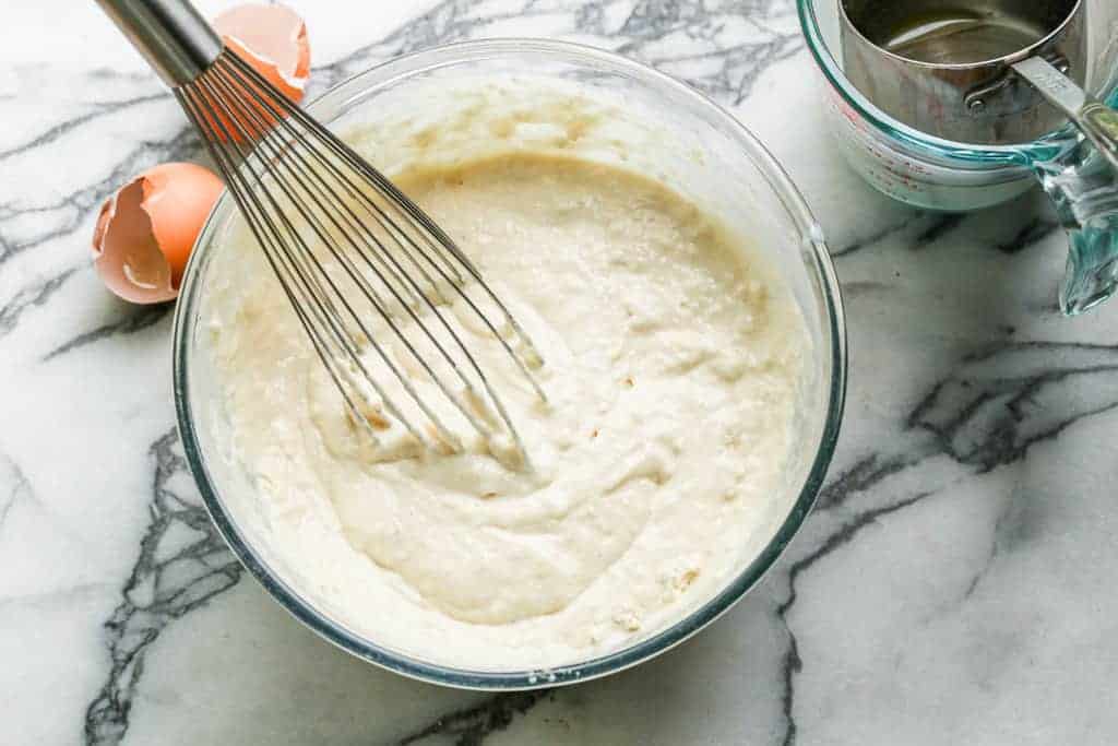 Buttermilk pancake batter in a mixing bowl with a whisk.
