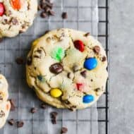 Large M&M cookies on a wore cooling rack.