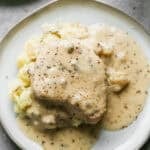 Fall apart slow cooker pork chops served over mashed potatoes in a creamy ranch gravy.