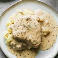 Fall apart slow cooker pork chops served over mashed potatoes in a creamy ranch gravy.