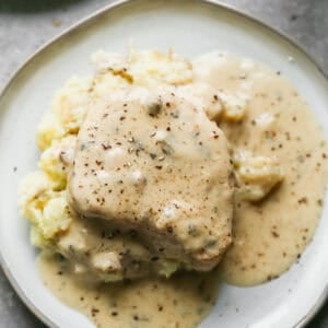 Fall apart slow cooker pork chops served over mashed potatoes in a creamy ranch gravy.