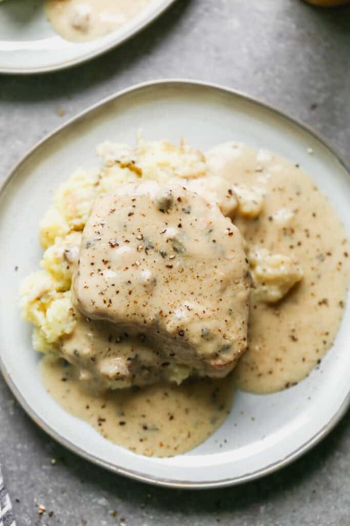Fall apart slow cooker pork chops served over mashed potatoes in a creamy ranch gravy.