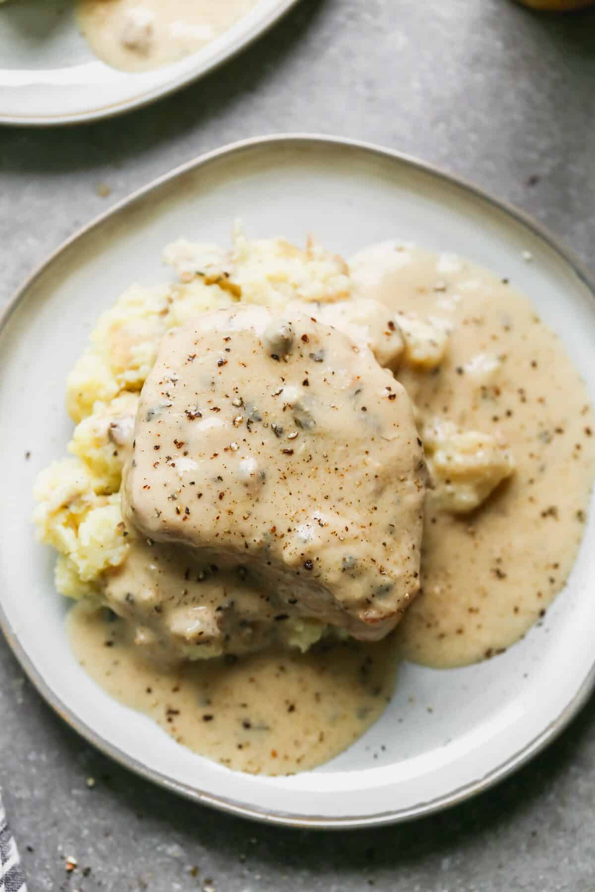 Fall apart slow cooker pork chops served over mashed potatoes in a creamy ranch gravy. 