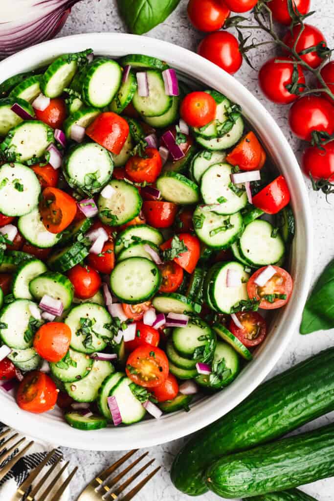 This easy Tomato and Cucumber Salad recipe allows the fresh ingredients to shine with sliced cucumbers, cherry tomatoes, red onion, basil, and oil and vinegar. It is vibrant and delicious and goes with any main dish!