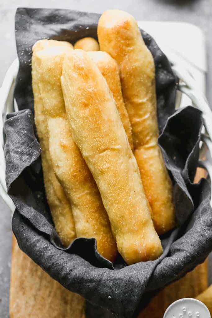 Long thin homemade breadsticks in a basket.