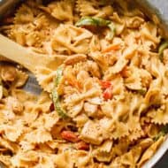Cajun Chicken Pasta in a large skillet with a wooden spoon.