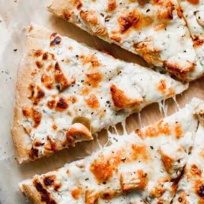 Pizza de pollo alfredo cortada en trozos.