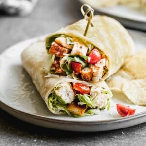 The best Chicken Caesar Salad Wrap with juicy chicken, crunchy lettuce, tomatoes, and a delicious dressing.