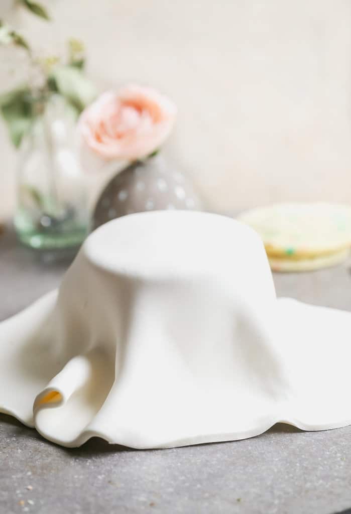 Una torta rotonda ricoperta da un foglio di fondente Marshmallow fatto in casa.