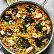 A large skillet full of chicken and seafood Paella.