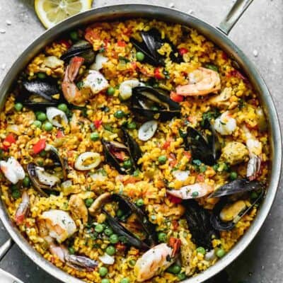 A large skillet full of chicken and seafood Paella.