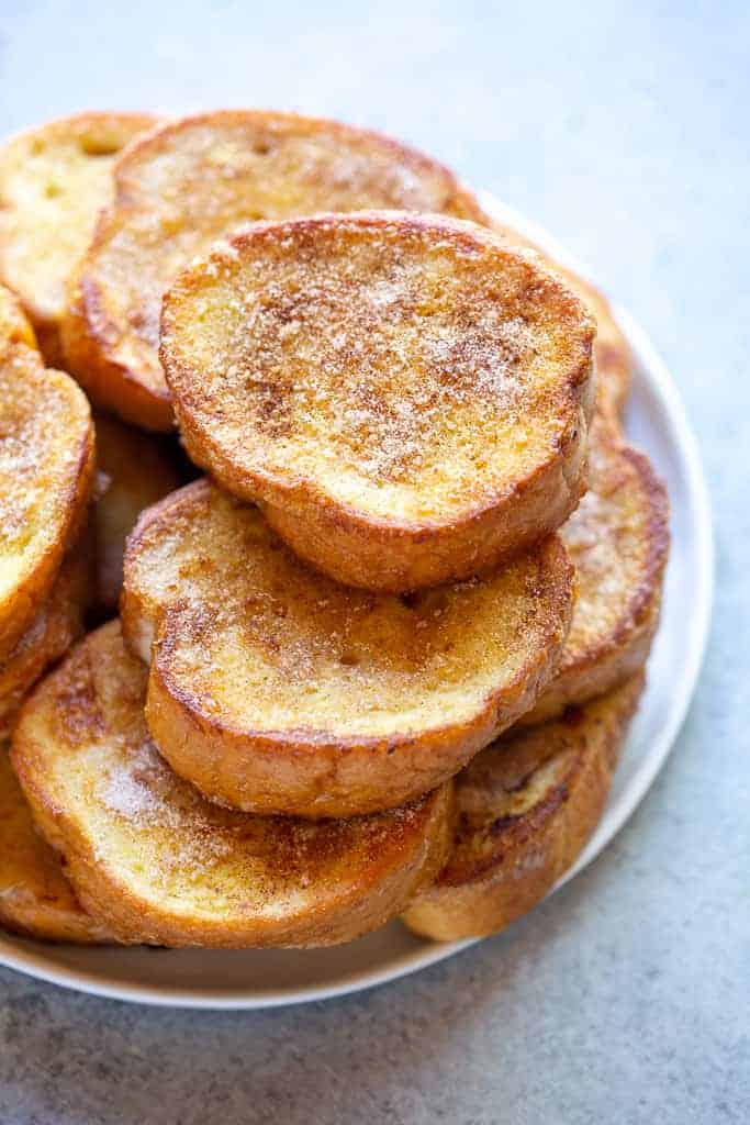A stack of Torrijas on a white plate.