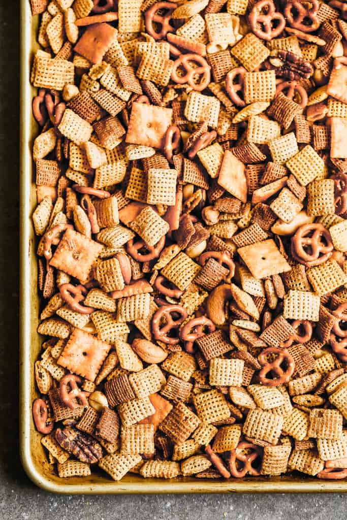 A baking sheet with seasoned, baked Chex mix.