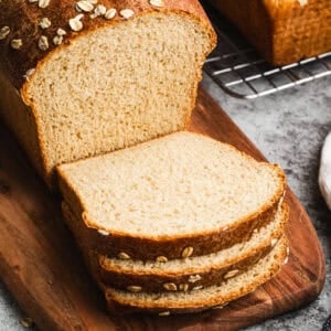 A loaf of homemade Oatmeal Bread with a few slices cut and ready to eat.