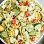 This easy Pesto Pasta Salad recipe has fresh tomatoes, cucumbers, and mozzarella cheese with pesto covered noodles. It's delicious!