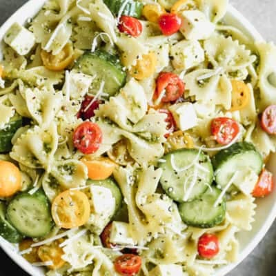 This easy Pesto Pasta Salad recipe has fresh tomatoes, cucumbers, and mozzarella cheese with pesto covered noodles. It's delicious!