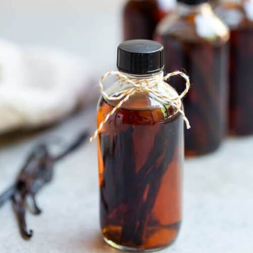 A small bottle of homemade vanilla extract with vanilla beans and vodka inside.