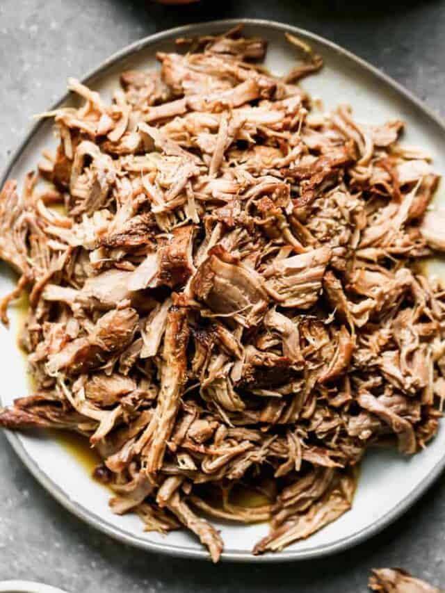 A pile of pulled pork on a white plate
