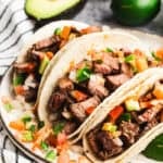 The best Carne Asada Tacos recipe has juicy, marinated meat chopped and in warm corn tortillas and topped with pico de gallo.