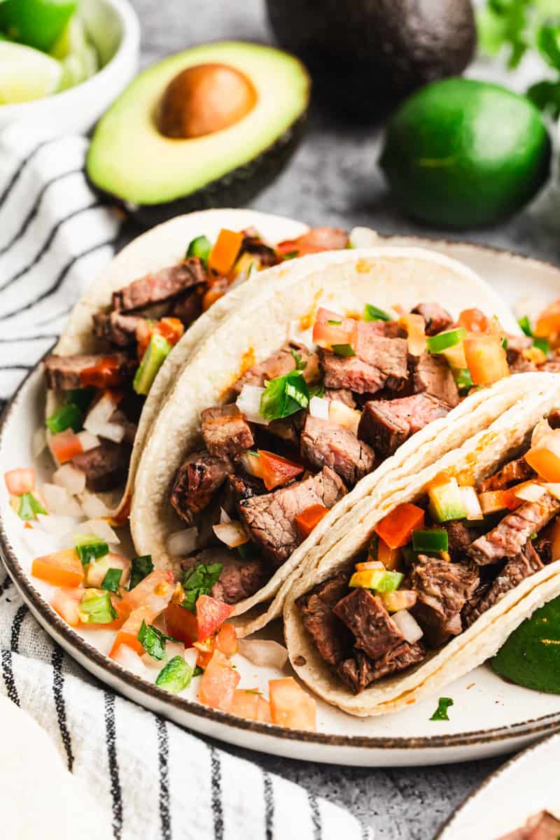 The best Carne Asada Tacos recipe has juicy, marinated meat chopped and in warm corn tortillas and topped with pico de gallo. 