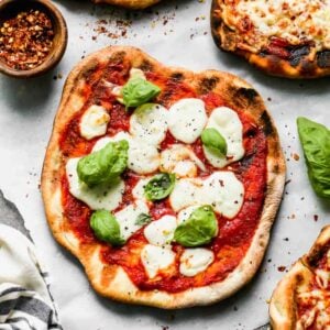 Grilled margherita pizza next to other flavors of pizza.