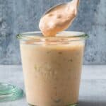 A cup with homemade Thousand Island Dressing with a spoon lifting some out.