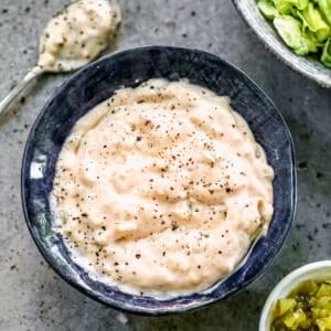 A bowl of homemade Thousand Island Dressing with a spoon next to it.