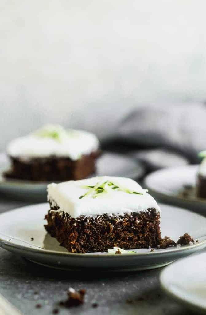 A zucchini brownie with cream cheese frosting, on a plate.