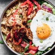 This flavorful Bulgogi Bowls is bold and delicious with a bed of kimchi fried rice, tender marinated pork, peppers, and an egg on top.