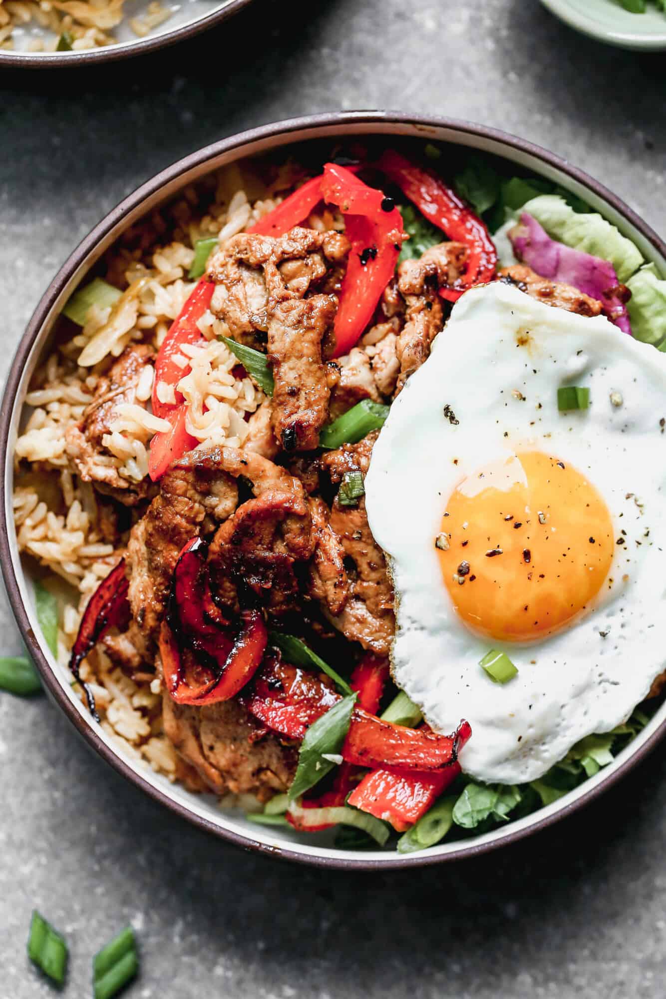 This flavorful Bulgogi Bowls is bold and delicious with a bed of kimchi fried rice, tender marinated pork, peppers, and an egg on top. 