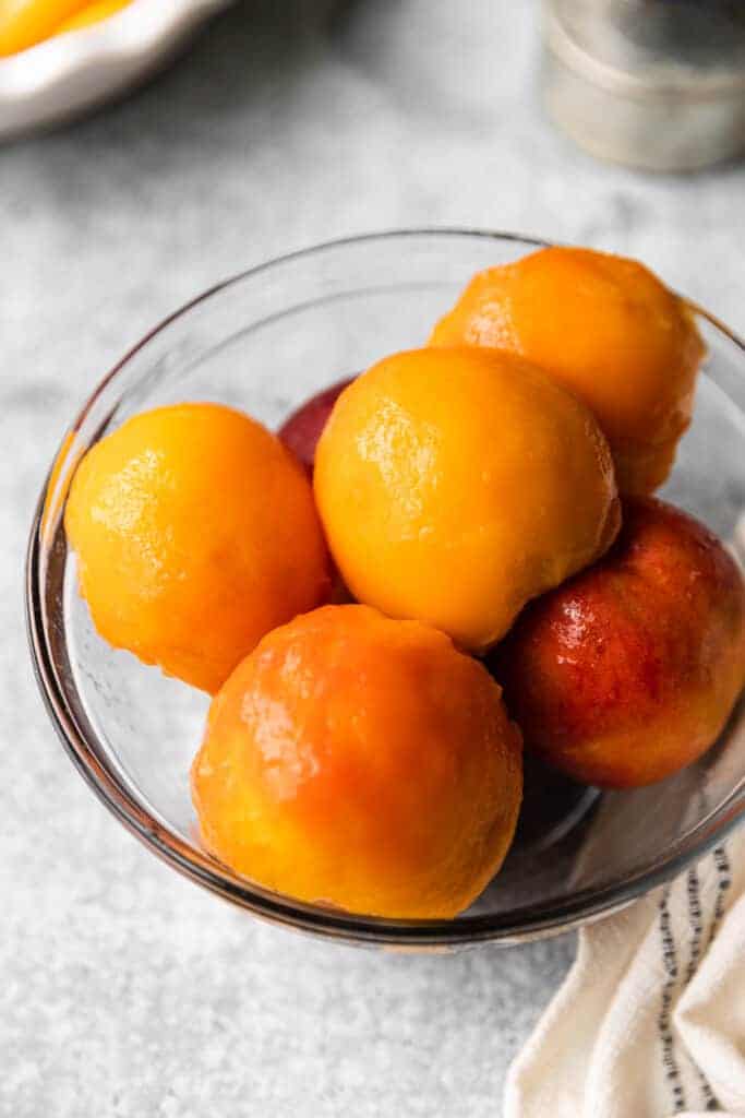 A bowl of peeled, fresh peaches.