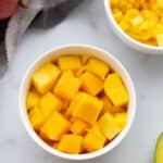 A bowl with cubed pieces of mango in it.