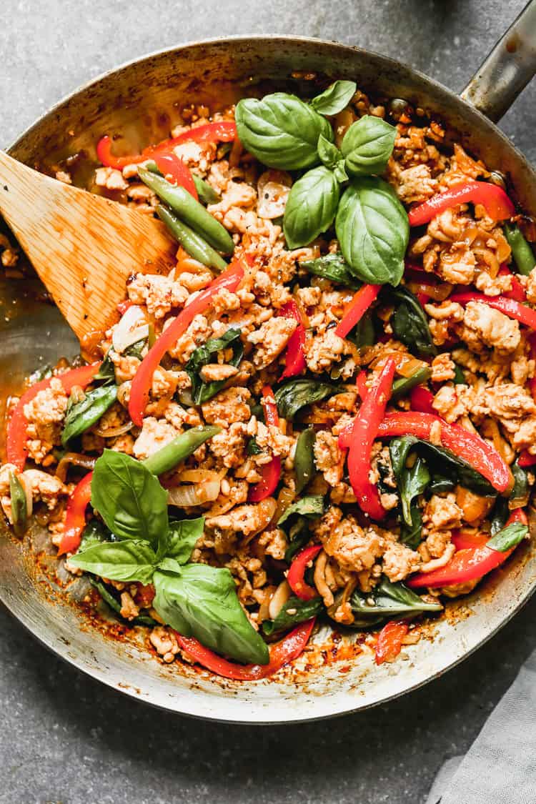 A pan filled with an easy Thai Basil Chicken recipe with ground chicken and fresh vegetables sautéed in a flavorful sauce.