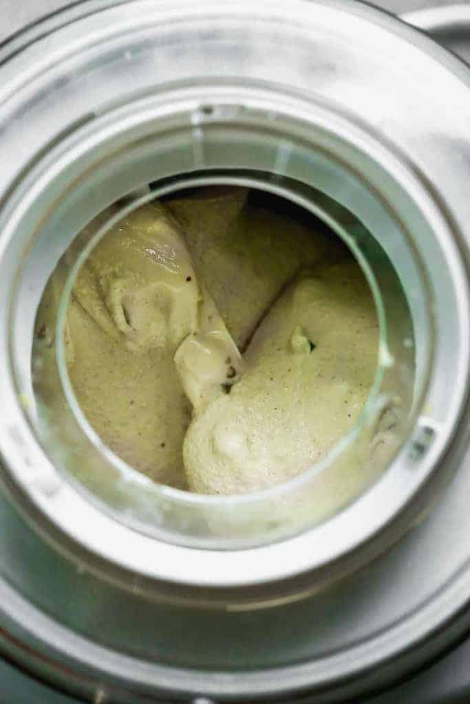 Pistachio ice cream churning in an ice cream maker.