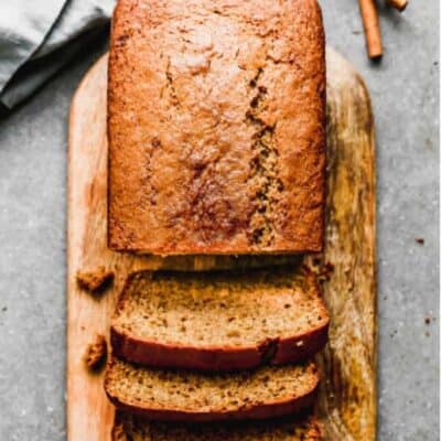 Apfelmusbrot auf einem Brotbrett, von dem drei Scheiben abgeschnitten sind.