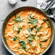 A bowl of the best Roasted Red Pepper Pasta with cheesy tortellini noodles and spinach in a bold and flavorful sauce.