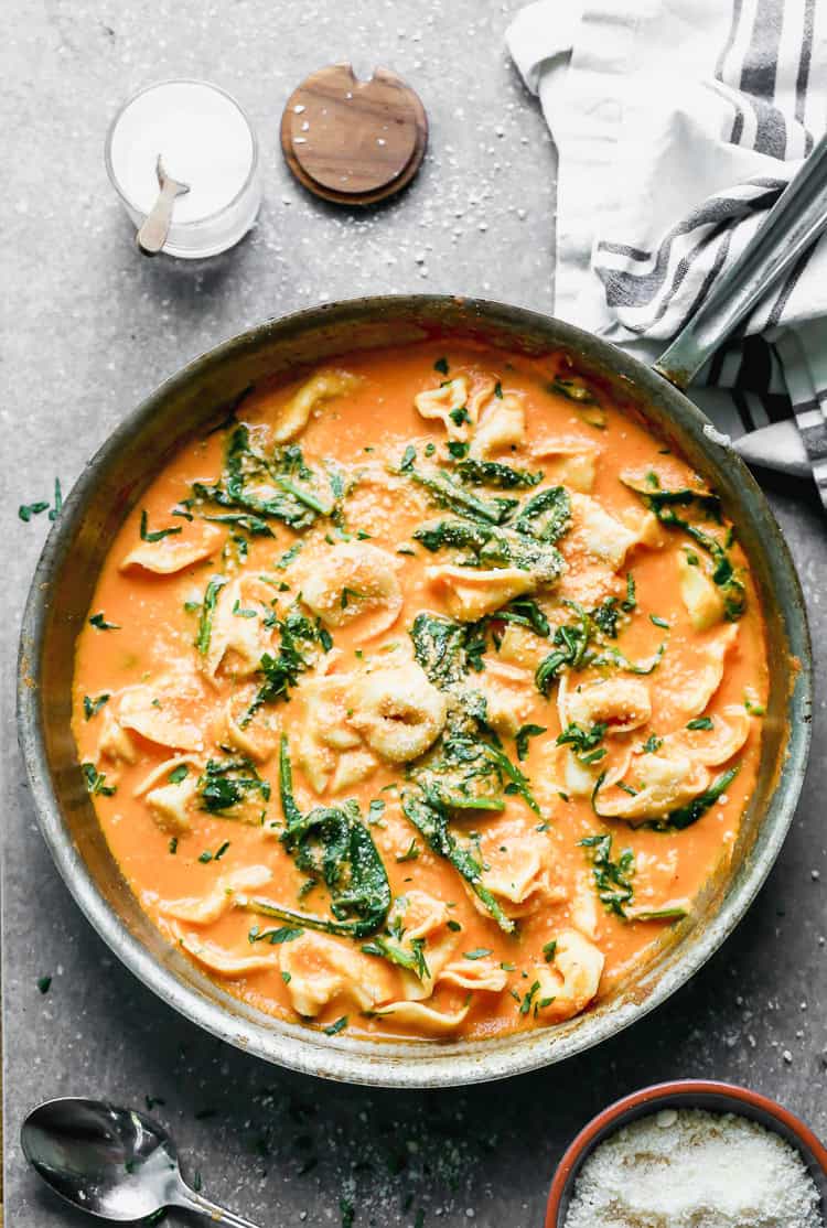 A bowl of the best Roasted Red Pepper Pasta with cheesy tortellini noodles and spinach in a bold and flavorful sauce.