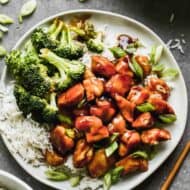 Teriyaki chicken served on a plate with white rice and steamed broccoli.
