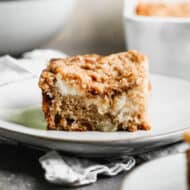 A piece of Apple Coffee Cake on a white plate, ready to enjoy.