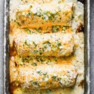 This green chile Smothered Burritos recipe is loaded with chicken and baked until golden, crispy, and covered in a green chile sauce.