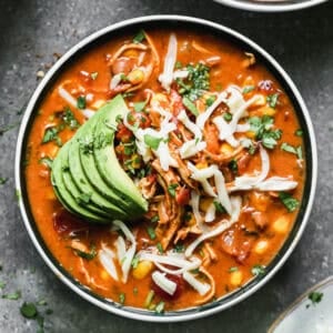 This Spicy Chicken Soup recipe is loaded with bold flavors from Mexican spices, chili beans, corn, and topped with all of the best toppings!