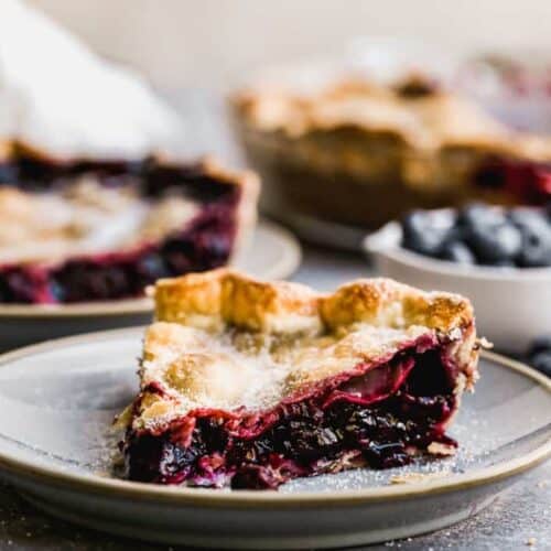 A slice of Blueberry Pie on a plate.