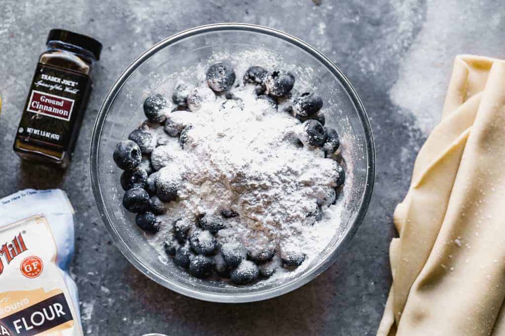 A mixing bowl with fresh blueberries and tapioca flour on top.