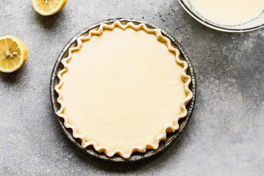 Chess pie batter poured into an unbaked pie shell.
