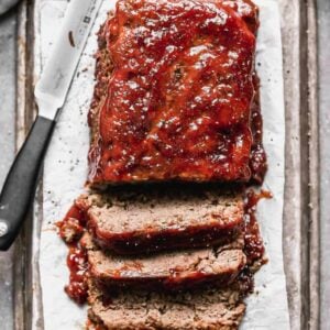 Meatloaf with meatloaf sauce on top, cut into slices.