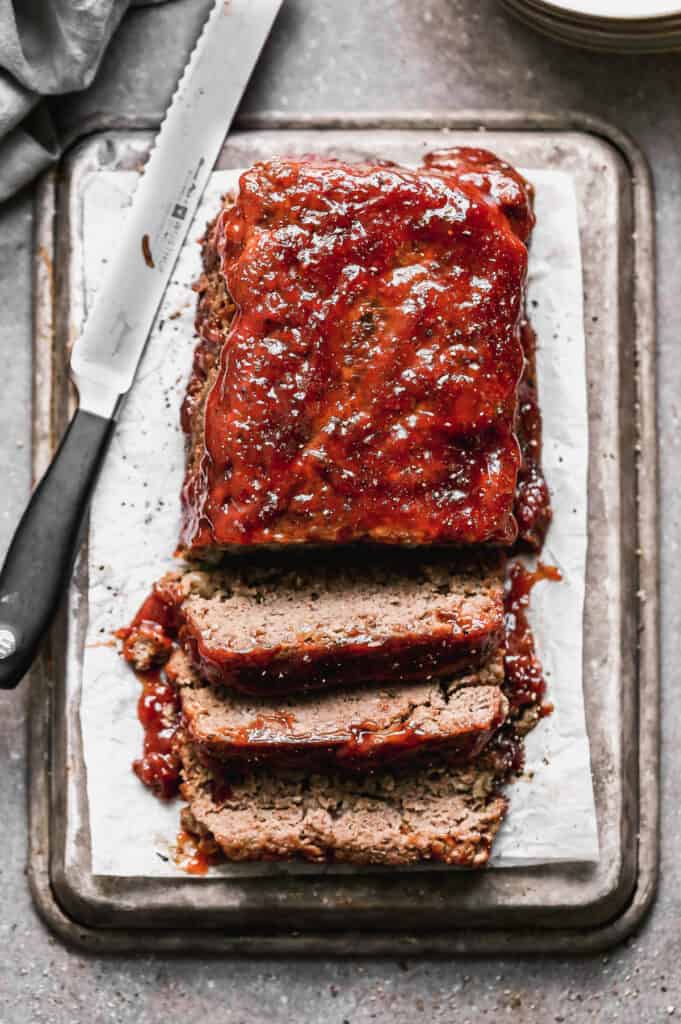 Meatloaf with meatloaf sauce on top, cut into slices.