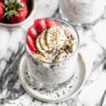 Easy Strawberry Overnight Oats in a glass cup topped with chopped strawberries, sliced bananas, and a sprinkle of chia seeds.