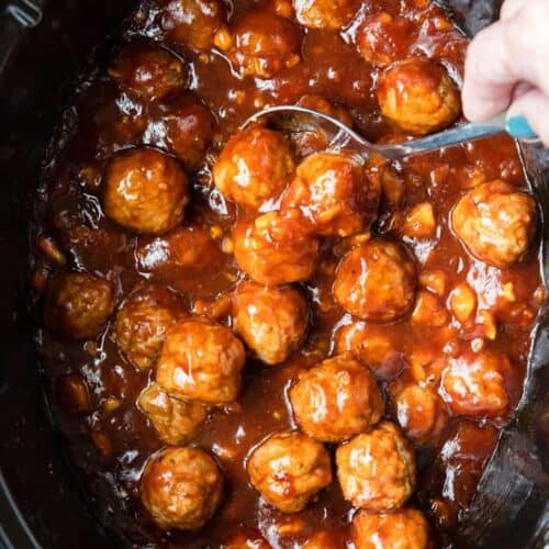 BBQ Hawaiian Meatballs in a slow cooker, being served with a spoon.