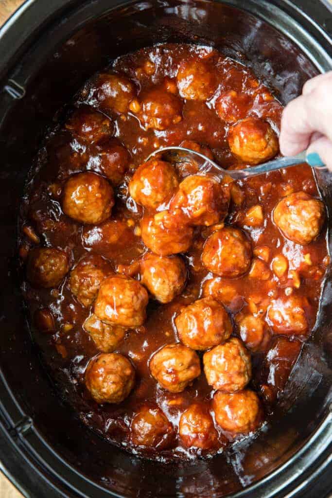 A slow cooker with Hawaiian Meatballs, ready to serve.