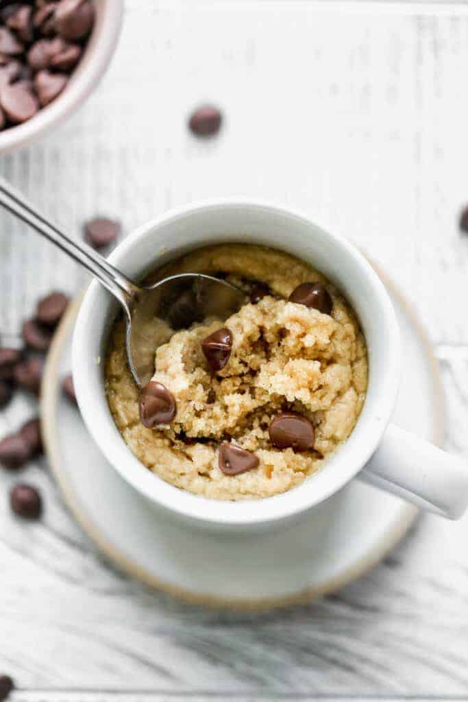 Peanut Butter Mug Cake with a spoon taking a bite out.